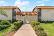 Pomona multi-family for rent - A building with a red tile roof and a white garage door.