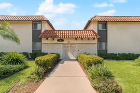 Pomona multi-family for rent - A building with a red tile roof and a white garage door.