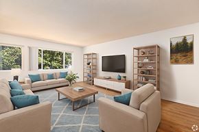 Lompoc multi-family for rent - A living room with a large couch, a coffee table, and a television.