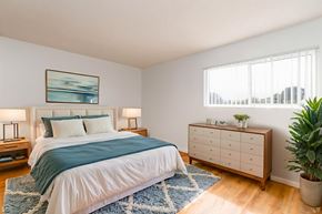 Lompoc multi-family for rent - A bedroom with a bed, nightstands, and a plant.