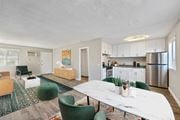 Moreno Valley apartment for rent - A modern kitchen with a white table and green chairs.