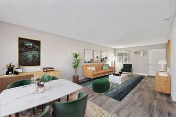 Moreno Valley apartment for rent - A living room with a white marble table and green chairs.