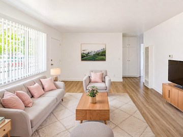 San Gabriel apartment for rent - A living room with a grey couch, a coffee table, and a painting on the wall.