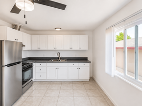 San Gabriel apartment for rent - A kitchen with white cabinets and a stainless steel refrigerator.