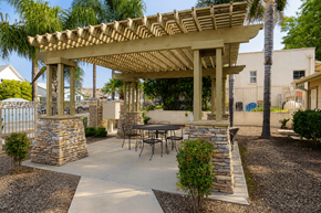 Lake Elsinore multi-family for rent - A patio with a table and chairs under a wooden pergola.