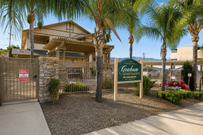 Lake Elsinore multi-family for rent - A sign for Graham Apartments is in front of a building with a fence and palm trees.