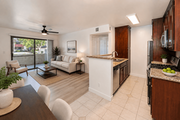 Lake View Terrace multi-family for rent - A modern kitchen and living room with white furniture and a ceiling fan.