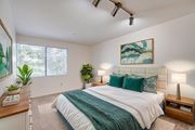 Pomona apartment for rent - A bedroom with a large bed and a painting on the wall.