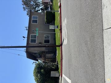 Alhambra multi-family for rent - A grey building with a green sign on the front.