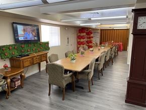 El Centro multi-family for rent - A conference room with a long table and chairs, a television on the left, and a clock on the right.