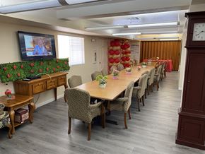 El Centro multi-family for rent - A conference room with a long table and chairs, a television on the left, and a clock on the right.