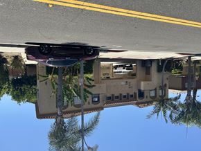 Gardena multi-family for rent - A car is reflected in a puddle on the street.