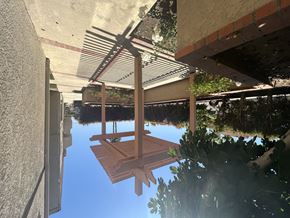 Gardena multi-family for rent - A wooden bench is suspended from a metal structure.