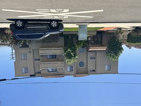 Gardena multi-family for rent - A car is parked in a parking lot above a house.