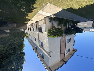 Wilmington multi-family for rent - A building with a green plant on the side is reflected in the water.