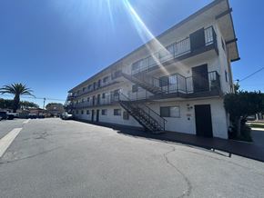 Wilmington multi-family for rent - A sunny day at a parking lot with a building in the background.