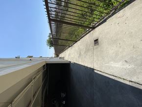 Los Angeles multi-family for rent - A concrete wall with a vent and a metal grate above it.
