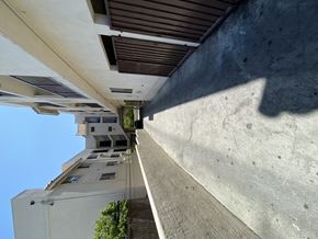 Los Angeles multi-family for rent - A building with a white facade and a brown roof is seen from a low angle.
