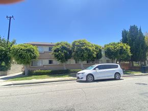Gardena multi-family for rent - A white van is parked on the side of a street in front of a house.