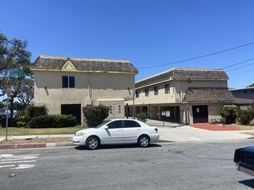 Lawndale multi-family for rent - A silver car is parked in front of a building with a red awning.