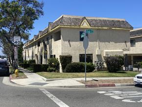 Lawndale multi-family for rent - A street view with a building, a car and a stop sign.