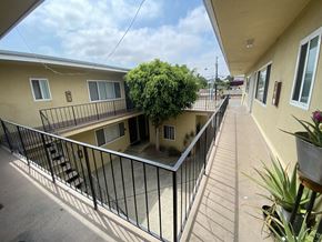 Harbor City multi-family for rent - A balcony with a metal railing and a potted plant on the right side.