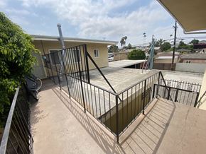 Harbor City multi-family for rent - A black metal fence surrounds a concrete patio.