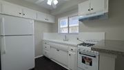 Temple City multi-family for rent - A white kitchen with a fridge, stove, and sink.