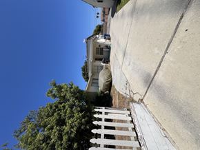 Torrance multi-family for rent - A house with a white fence and a tree in front of it.