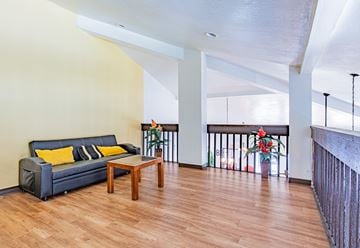Paramount apartment for rent - A living room with a black couch and a wooden coffee table.