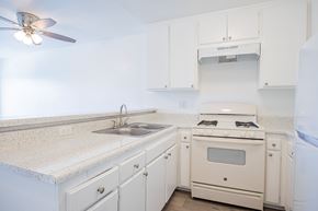 Paramount apartment for rent - A white kitchen with a fan on the ceiling.
