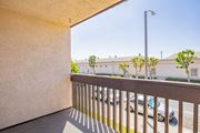 Paramount apartment for rent - A balcony with a metal railing and a view of a street with cars and buildings.