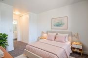 Paramount apartment for rent - A bedroom with a pink bed and a painting on the wall.
