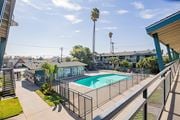 El Monte apartment for rent - A pool surrounded by a fence and a building in the background.