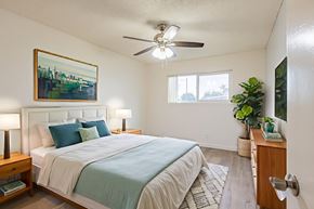 Bellflower multi-family for rent - A bedroom with a bed, nightstand, and a painting on the wall.