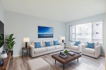Bellflower multi-family for rent - A living room with a large painting on the wall and two white couches.
