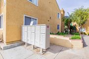 Corona multi-family for rent - A mailbox is on the sidewalk in front of a tan building.