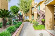 Corona multi-family for rent - A pathway leads to a building with a green door.