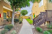 Corona multi-family for rent - A tree in front of a building with a yellow door.