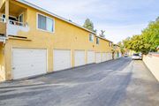 Corona multi-family for rent - A street view of a residential area with apartment buildings and parked cars.