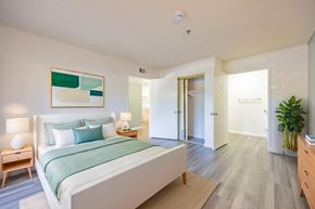 Santa Clarita multi-family for rent - A bedroom with a bed, nightstand, and lamp.