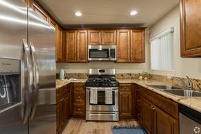 San Bernardino multi-family for rent - A modern kitchen with wooden cabinets and stainless steel appliances.