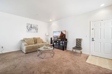 Canoga Park multi-family for rent - A living room with a brown carpet and a white door.