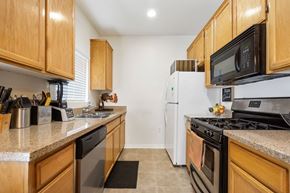Canoga Park multi-family for rent - A kitchen with a white refrigerator and black stove.