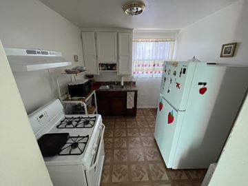 Maywood multi-family for rent - A kitchen with a white fridge and a white stove.