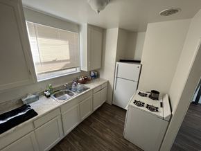 Maywood multi-family for rent - A kitchen with a fridge, a stove, and a sink