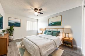 La Puente apartment for rent - A bedroom with a large bed, a ceiling fan, and two pictures on the wall.