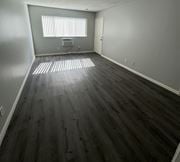 Pomona apartment for rent - A room with wooden flooring and a window with blinds.