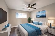 Montebello multi-family for rent - A bedroom with a bed, a ceiling fan, and a painting on the wall.