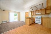 Hemet multi-family for rent - a kitchen and living room with a sliding glass door leading to a patio at Oak Terrace Senior Apts, Hemet California